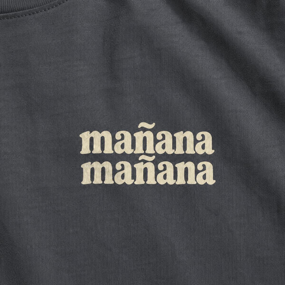 Black t-shirt with 'mañana mañana' text in beige.