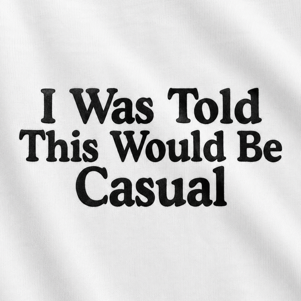 White fabric with black printed text reading 'I Was Told This Would Be Casual' in a bold serif font.