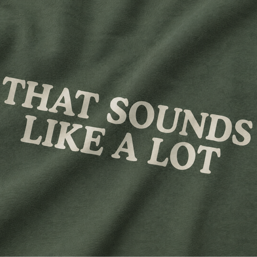 Close-up of a dark olive green fabric surface with large cream text reading “THAT SOUNDS LIKE A LOT.”